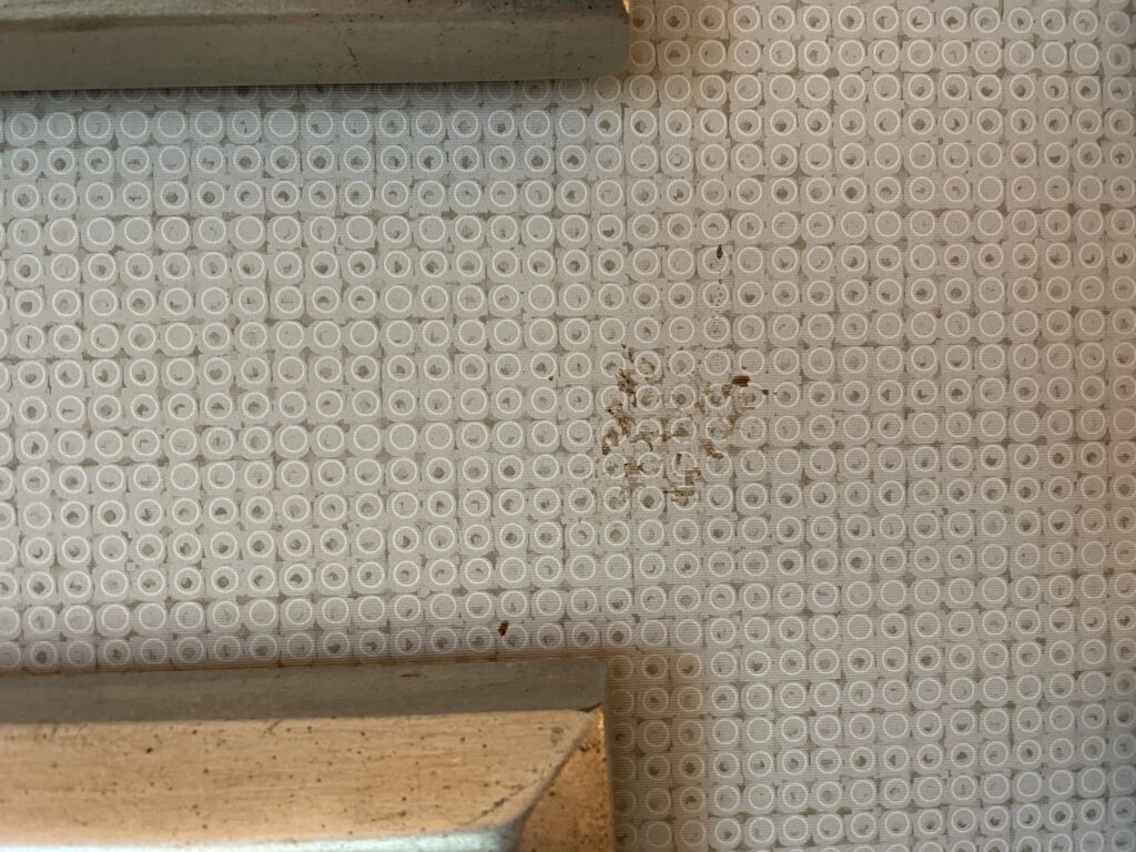 A stain on the wallpaper below the TV.