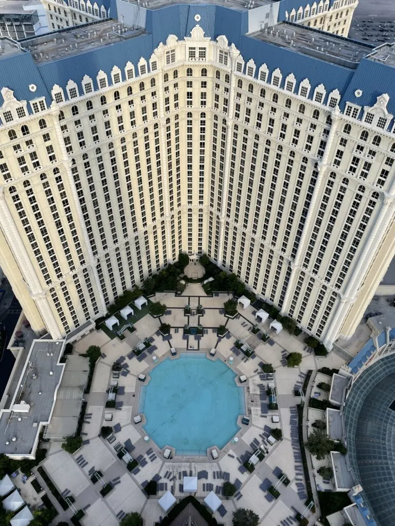 The circular Soleil rooftop pool and Paris' hotel tower viewed from above.