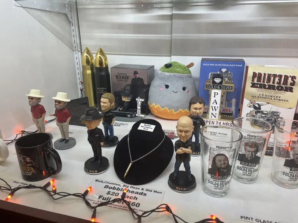 A number of Pawn Stars character bobbleheads in a glass case