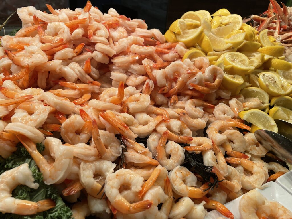 A pile of shrimp with cut lemons piled to the right.