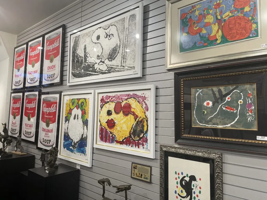 Artwork depicting snoopy, Campbells soup cans, etc. displayed on thew wall. 