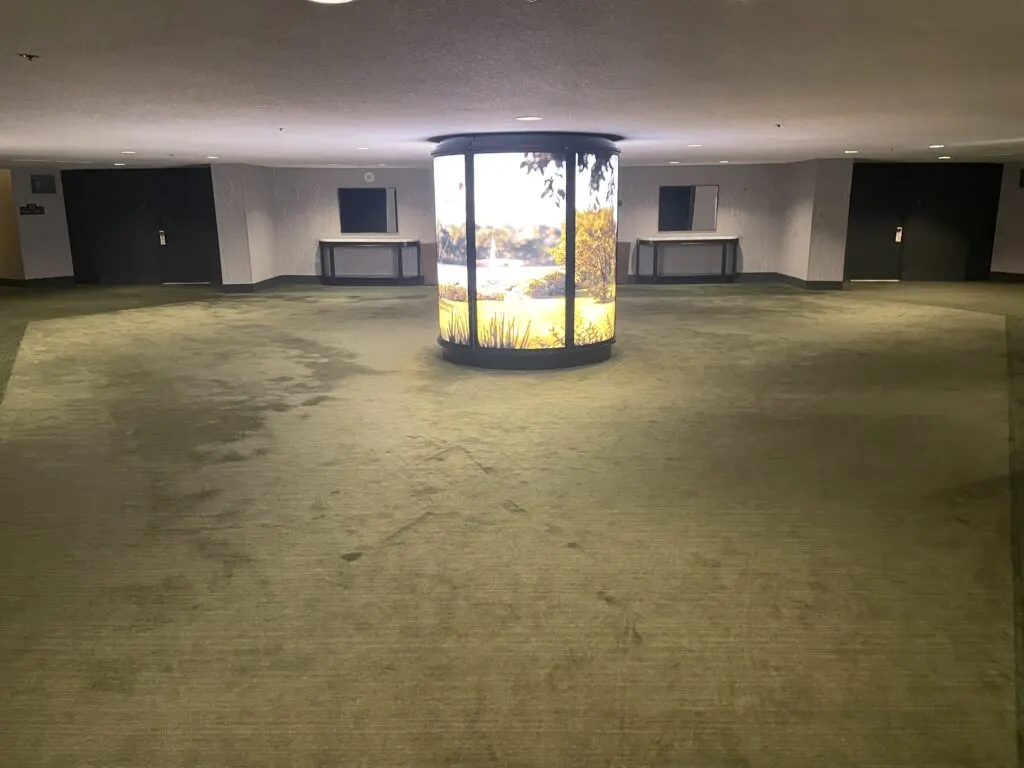 Park MGM Hotel Lobby, which has an illuminated decor piece in the center and dark green carpet throughout. 