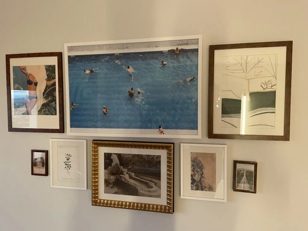 8 pictures of different sizes hanging on a wall. 