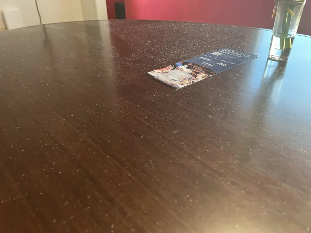 A brown table top with white dust visible.