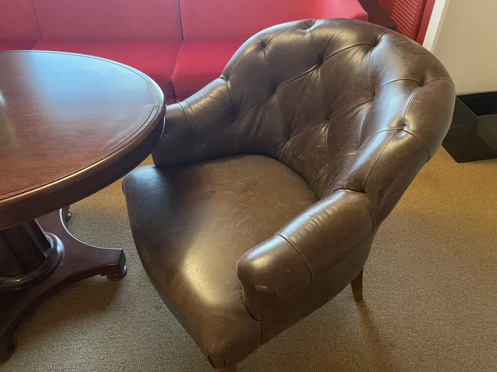 A brown leather chair at the coffee table.