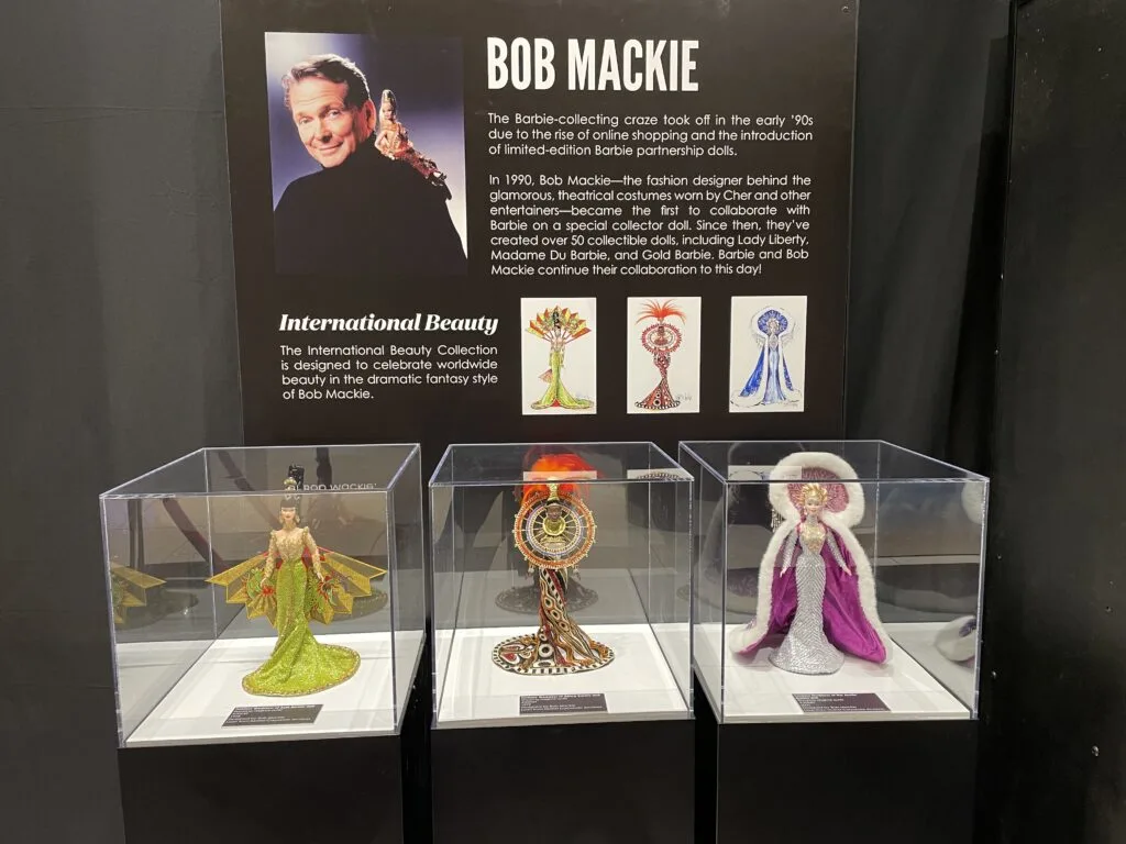 3 dolls wearing international fashions designed by Bob Mackie. 