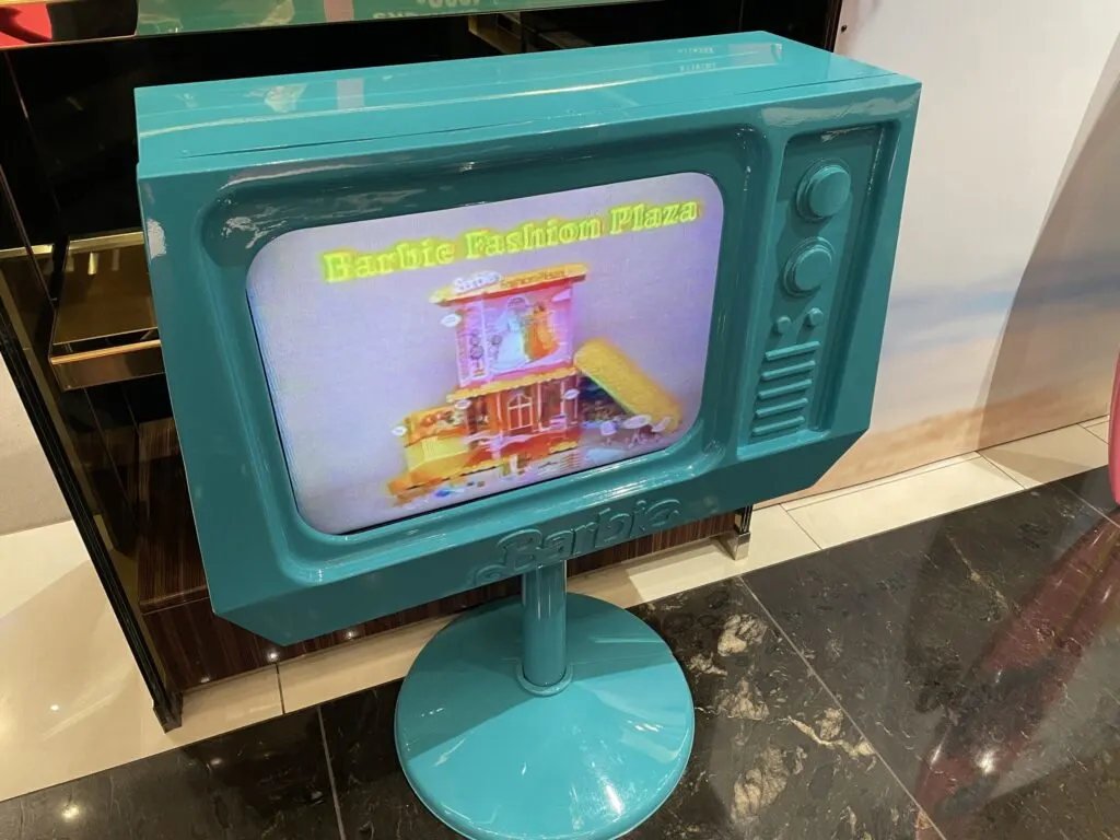A mock TV playing a barbie doll commercial from the 1980s or 1990s.