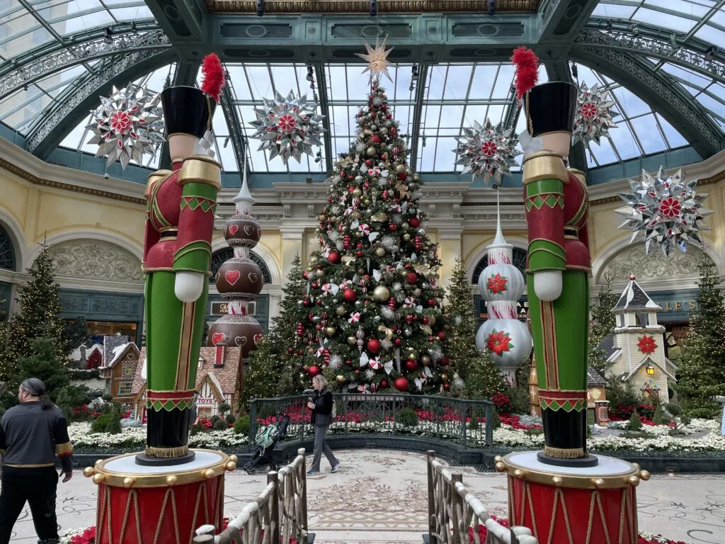 A Christmas Tree is flanked by 2 nutcrackers in Bellagio's Holiday display.