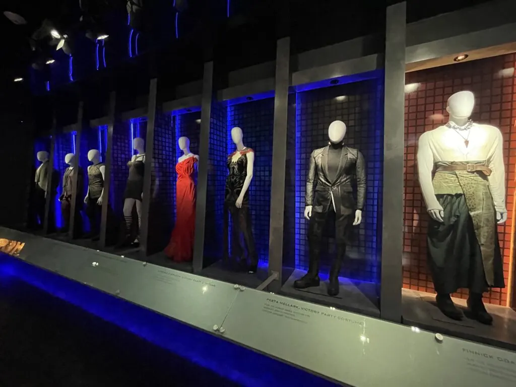 A wall of movie costumes on manequins. 