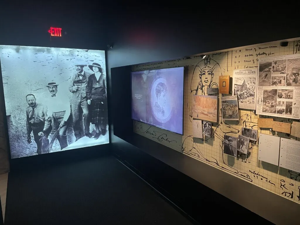 A room displaying old newpaper clippings and video about Howard Carter. 