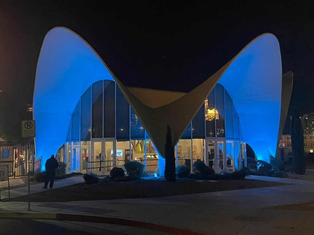 The La Concha motel lobby illuminated in blue at night.