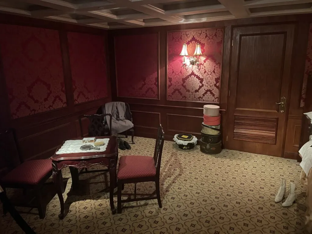 Another portion of the first class stateroom that has a small dining room table and chairs. 