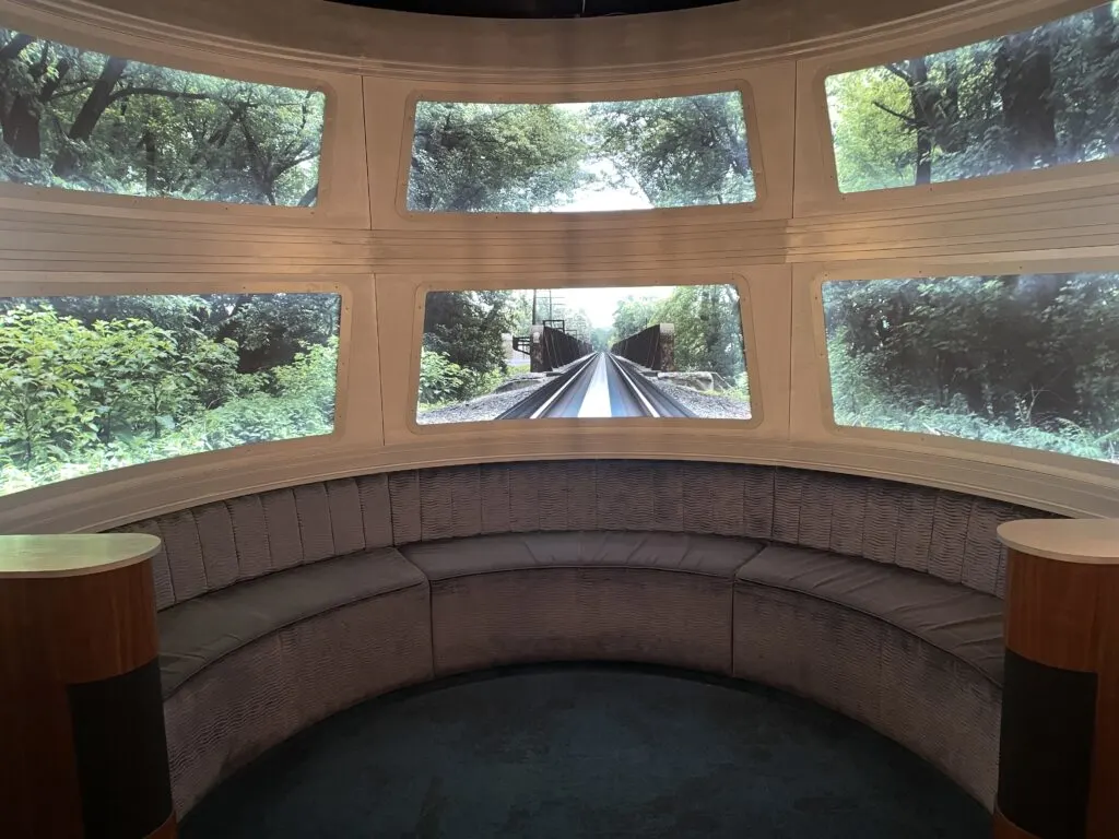 A bench on the "train" with 6 windows that had a view outside into the surrounding forest. 