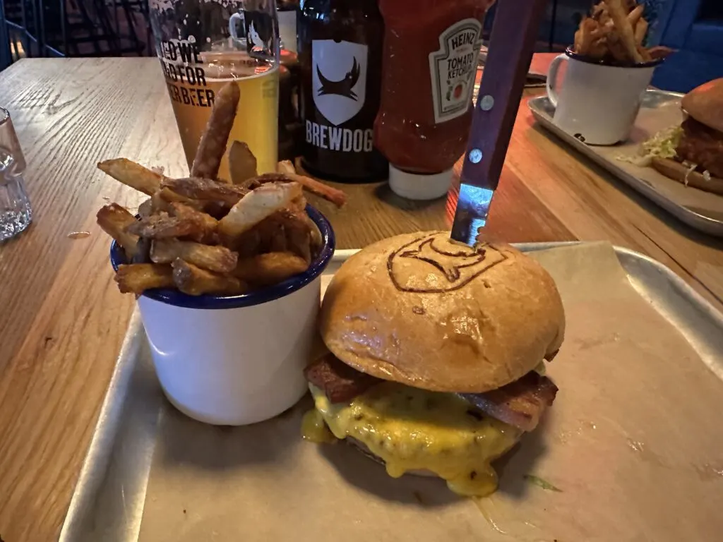 Bacon Deluxe Cheeseburger and a side of fries in a cup.