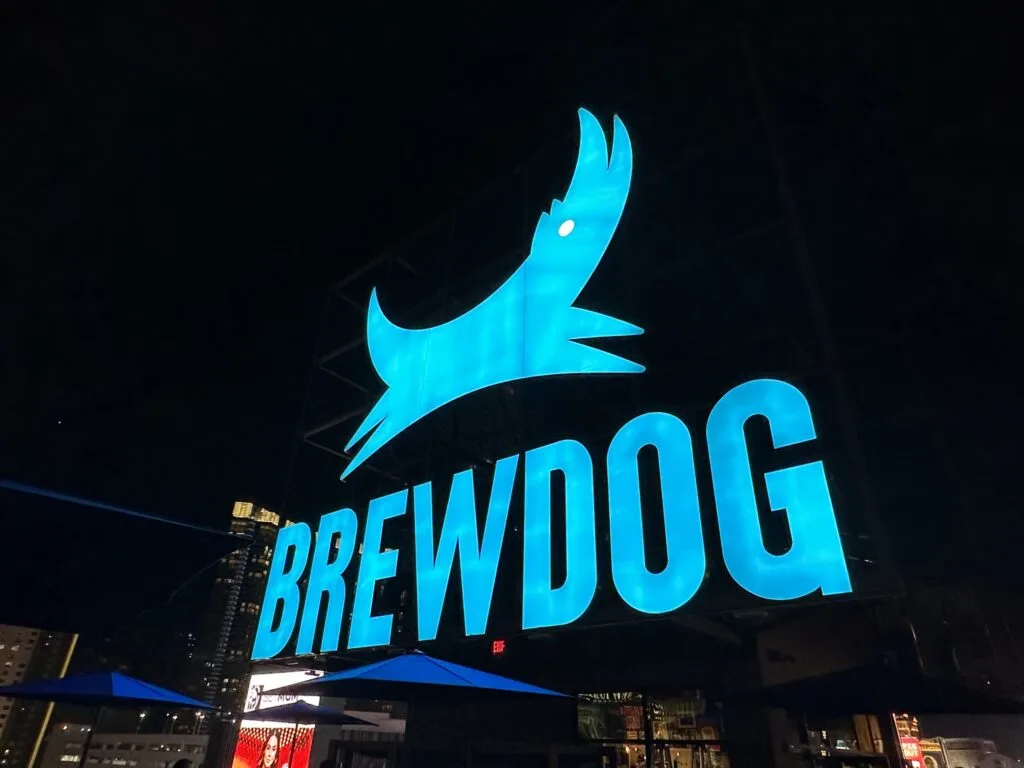Brewdog marquee, which is a dog above the word BREWDOG, illuminated in blue.