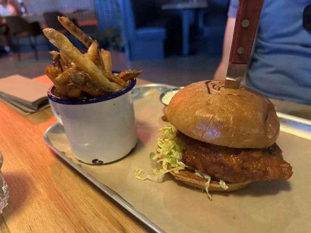 Buffalo Chicken Sandwich and a side of fries in a cup. 