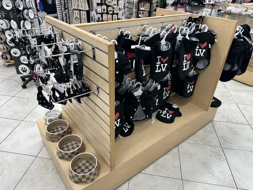 Dog shirts with "I Love Las Vegas" written on them are hanging on a rack. 