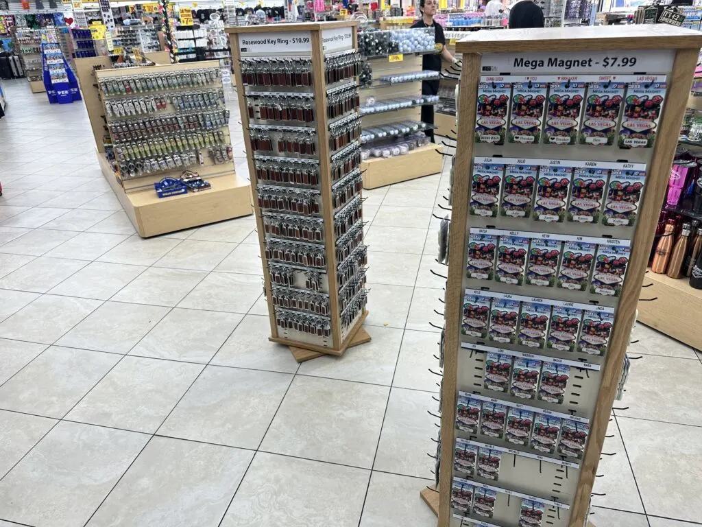 Keychains with various names on them hang from a 2 spinning racks. 