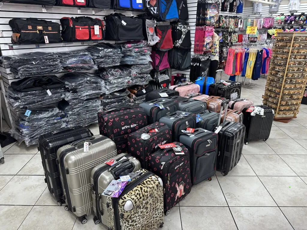 Suitcases of various sizes and colors are lined up on the sales floor. 