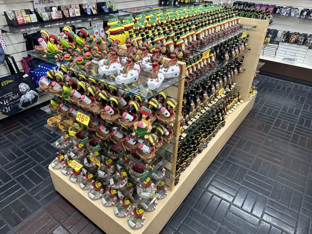 Assorted "Jamacian themed" pipes are lined up on a display case. 