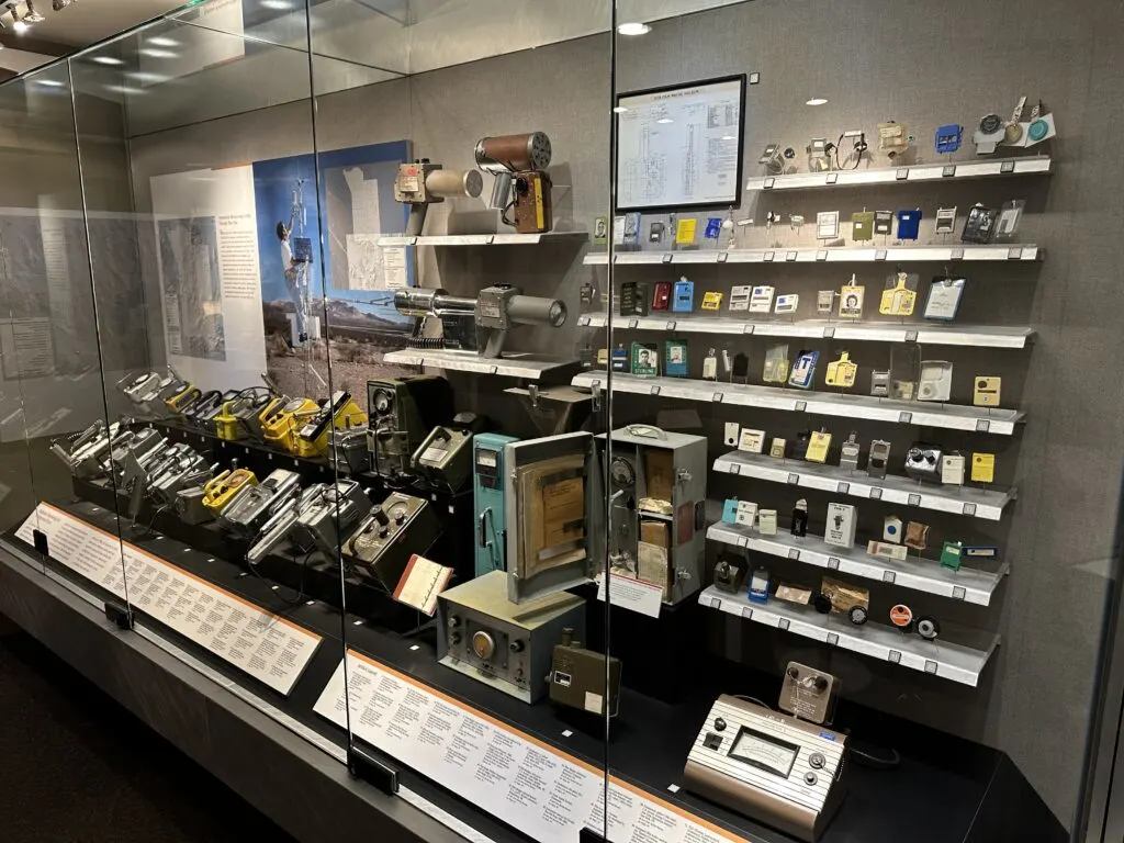 A wide array of radiation detectors behind glass.