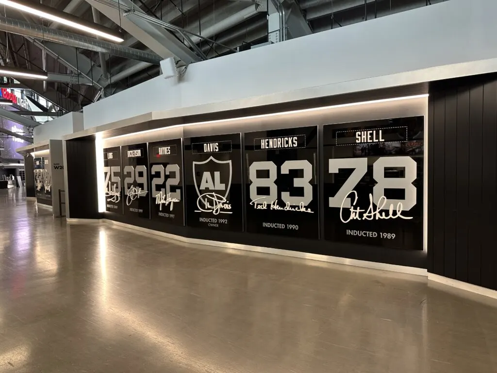 A portion of the Raiders Wall of Fame along a concourse at Allegiant Stadium that features Al Davis. 