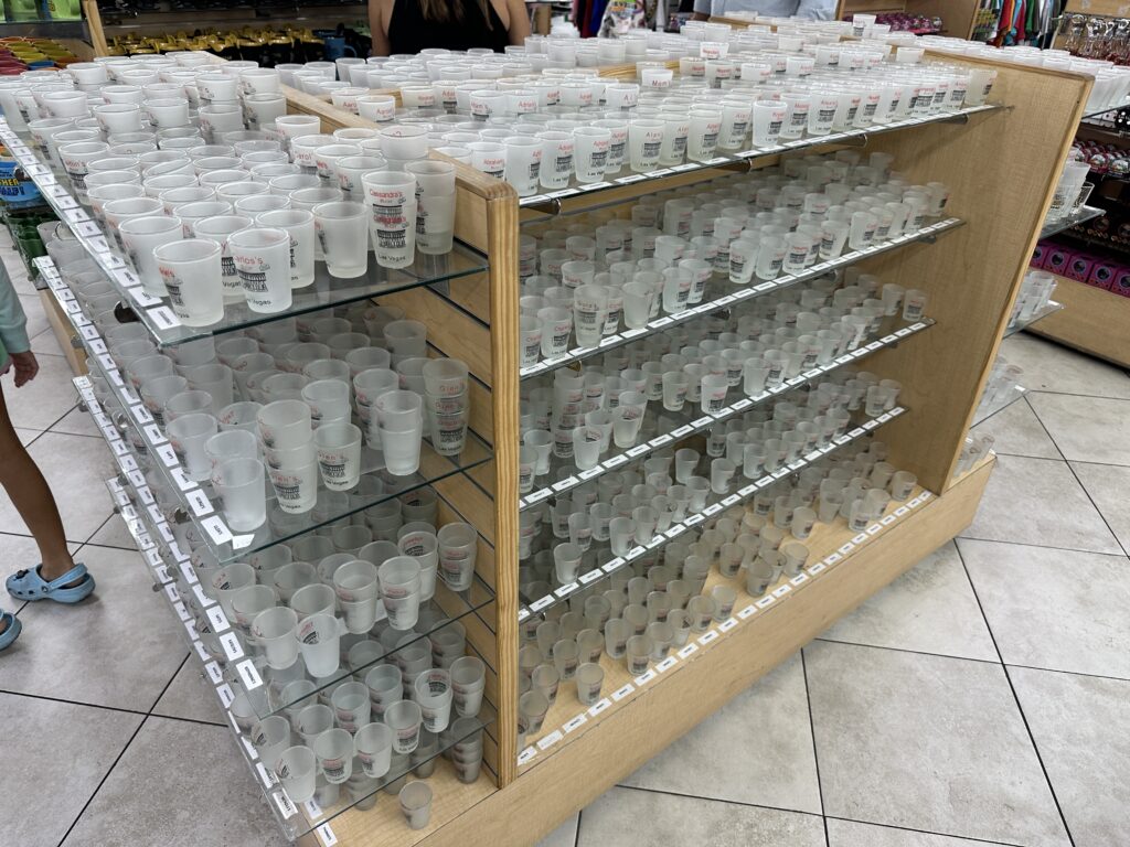 Hundreds of shot glasses on a display case. 