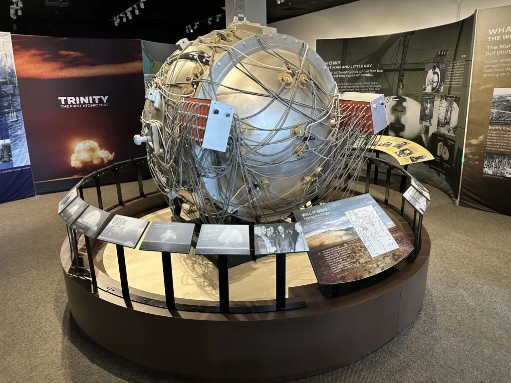 A large metallic sphere with various wires wrapped around it designed to look like the Gadget test device.