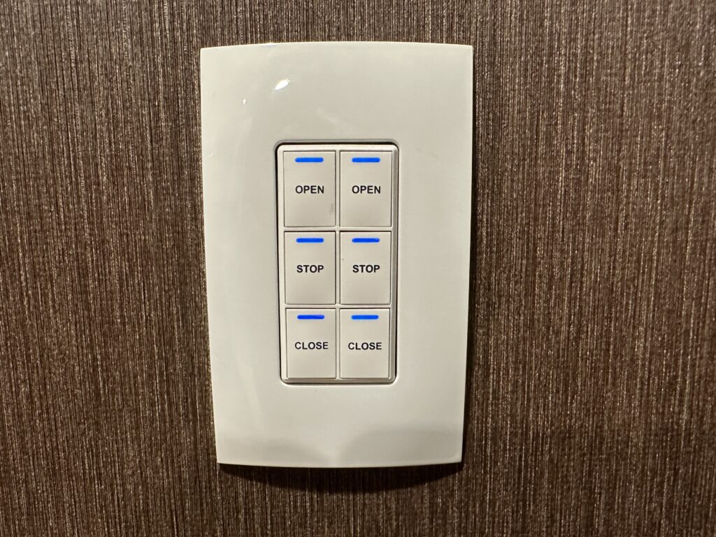 A control Panel switch with buttons to open, stop, and close the sheer and blinds. 