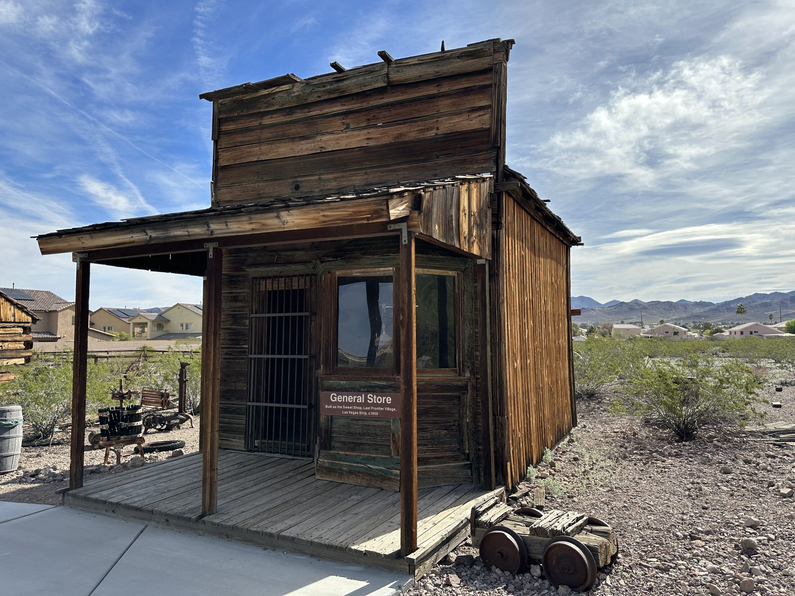 A weathered building with a front covered porch labled 