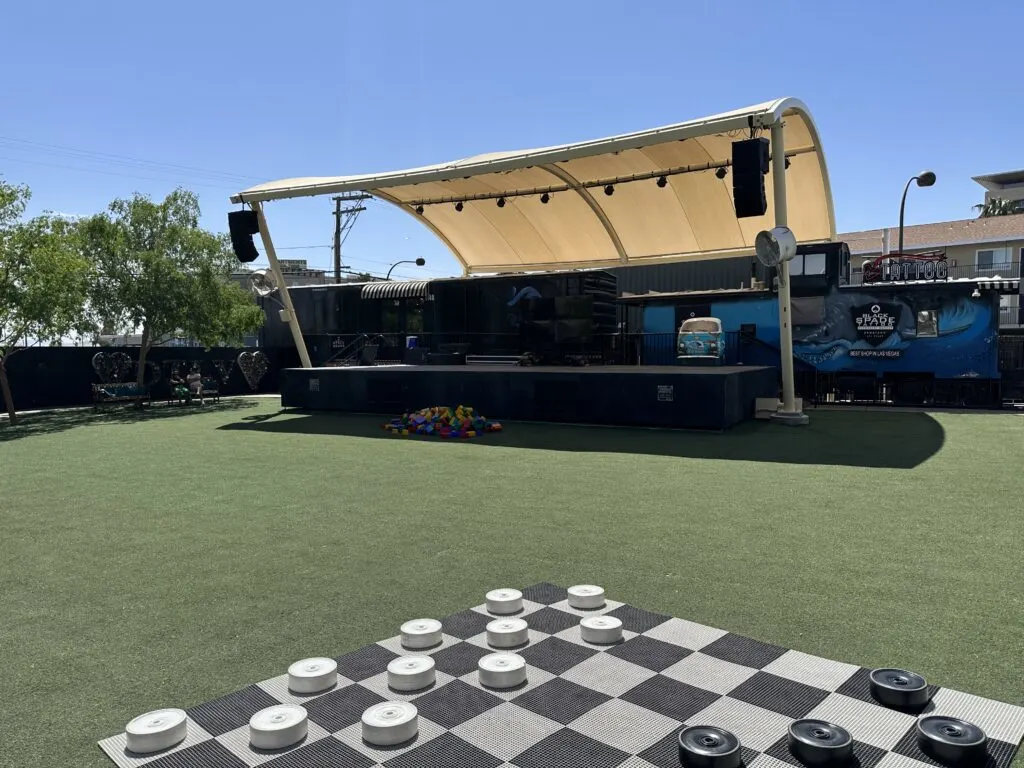 An entertainment stage with planty of green space for sitting/standing in the back of the Container Park complex.