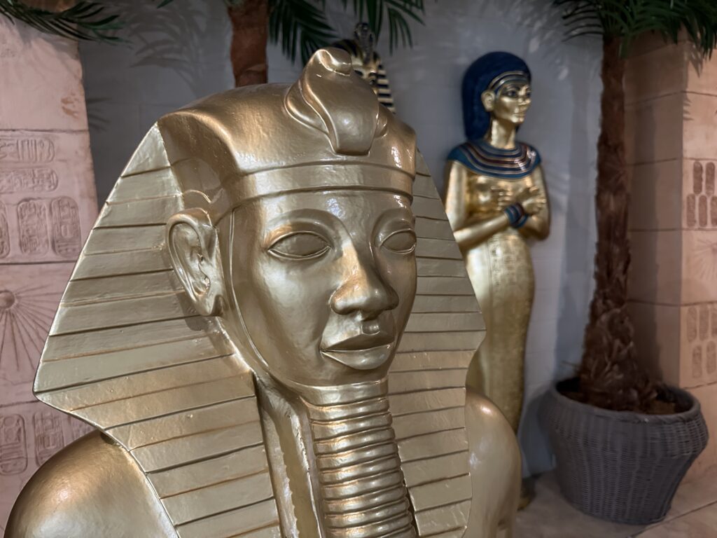 Two golden statues depicting ancient egyptions stand guard at the entrance to the exhibit. 