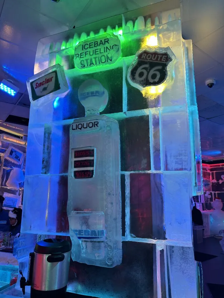 A wall of ice with a gasoline pump, and two signs that say "Sinclair", and "Route 66" above it. 