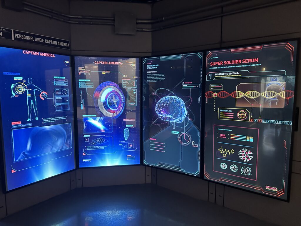 Backlit informational placards on the wall describing Captain America's character and powers.