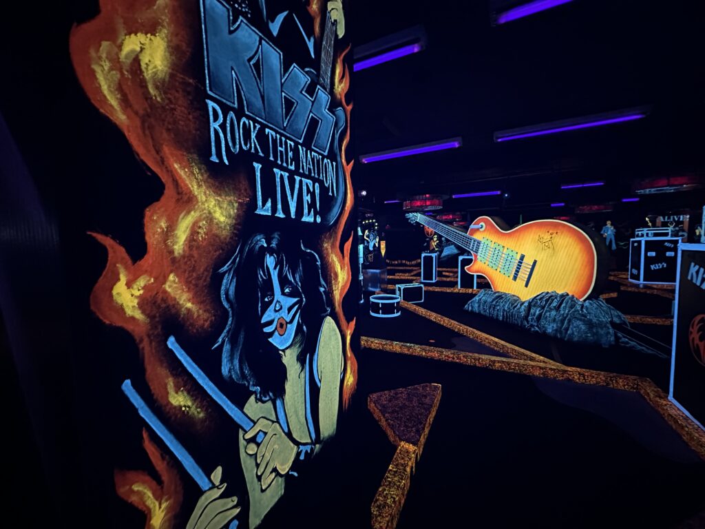 Glowing wall art depicting a band member that says "Kiss, Rock the Nation LIVE".