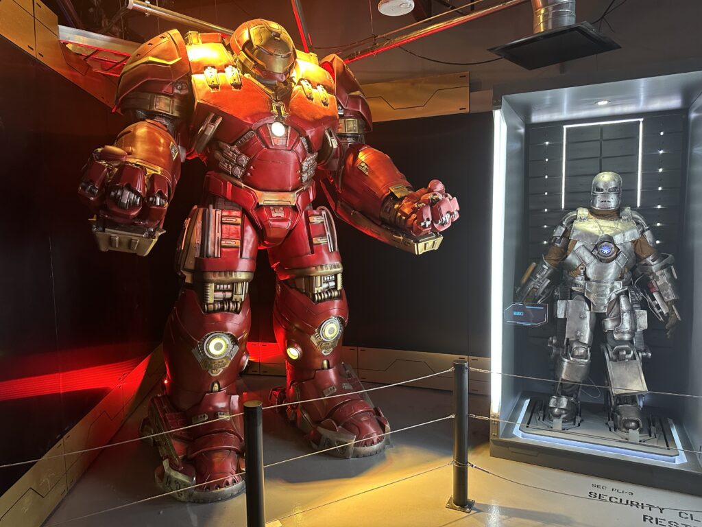 A massive, 8 foot tall Iron Man Suit posing next to a smaller one. 