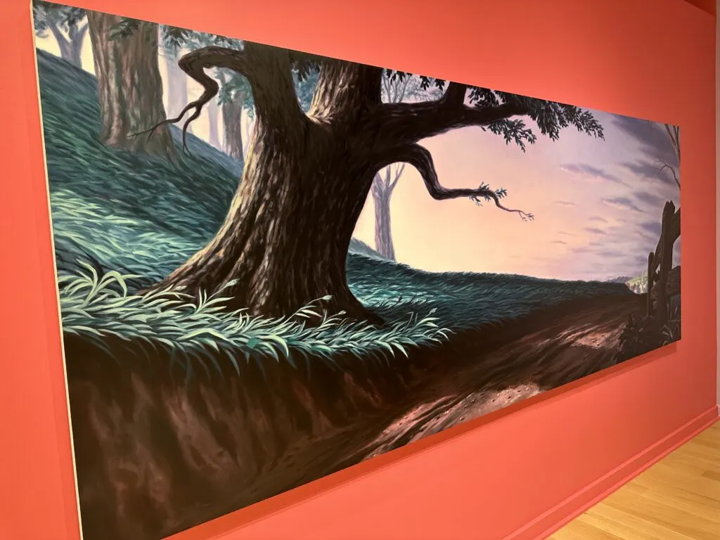 A large painting of a dirt trail winding past a dark, thick tree that has an almost ominous look.