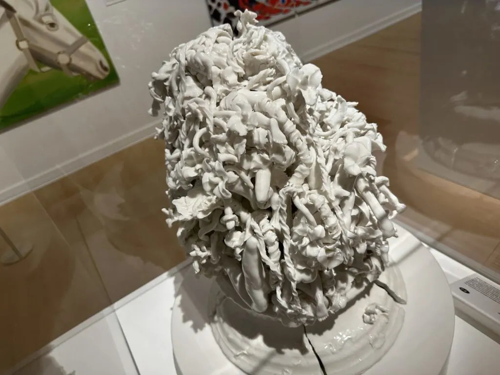 A very detailed porcelain sculpture in a glass case. 