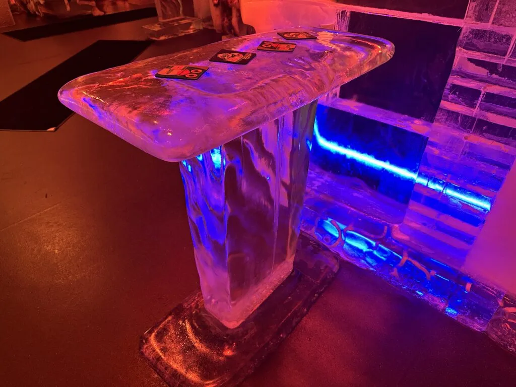 A standing table made entirely of smooth and transparent ice. 