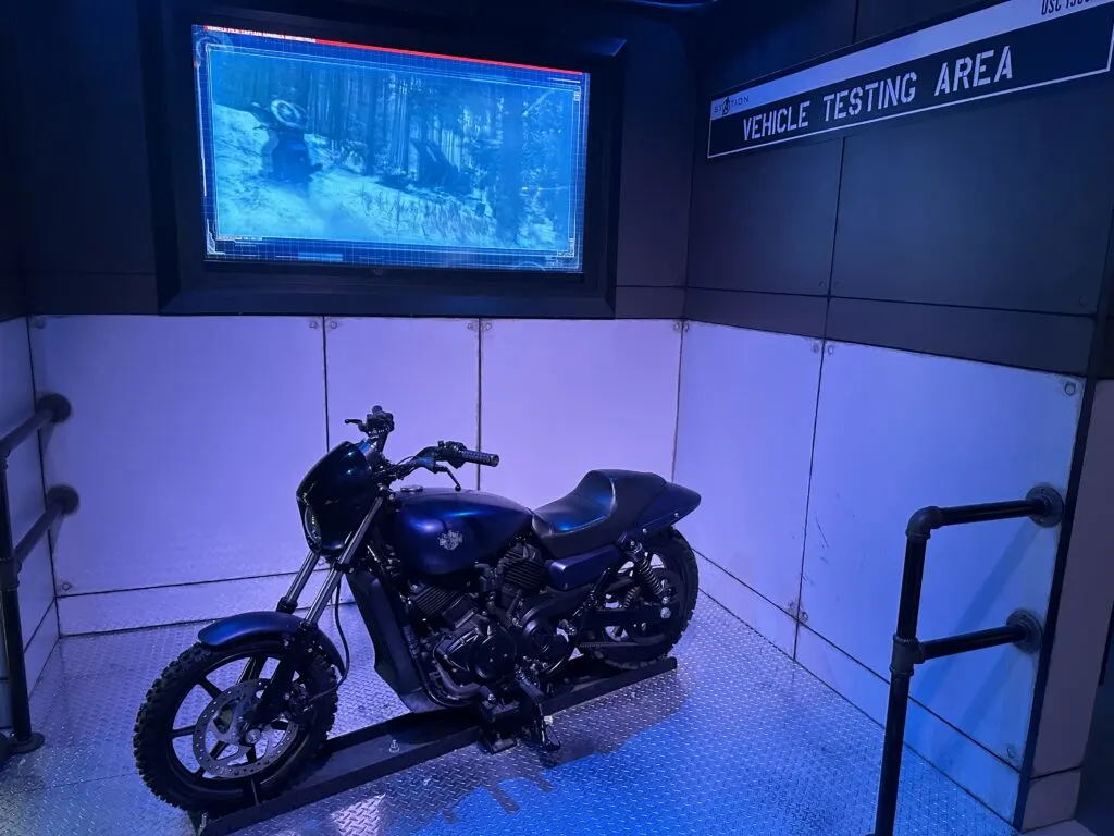 A motorcycle is on display in the "Vehicle Testing Area".
