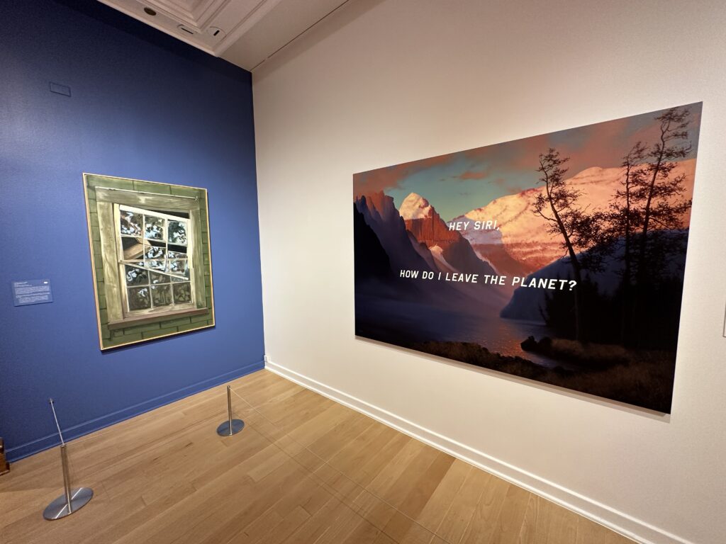 2 pictures on the wall. The right one is a picture of mountains and forests and reads "Siri, How do I leave the planet?". 