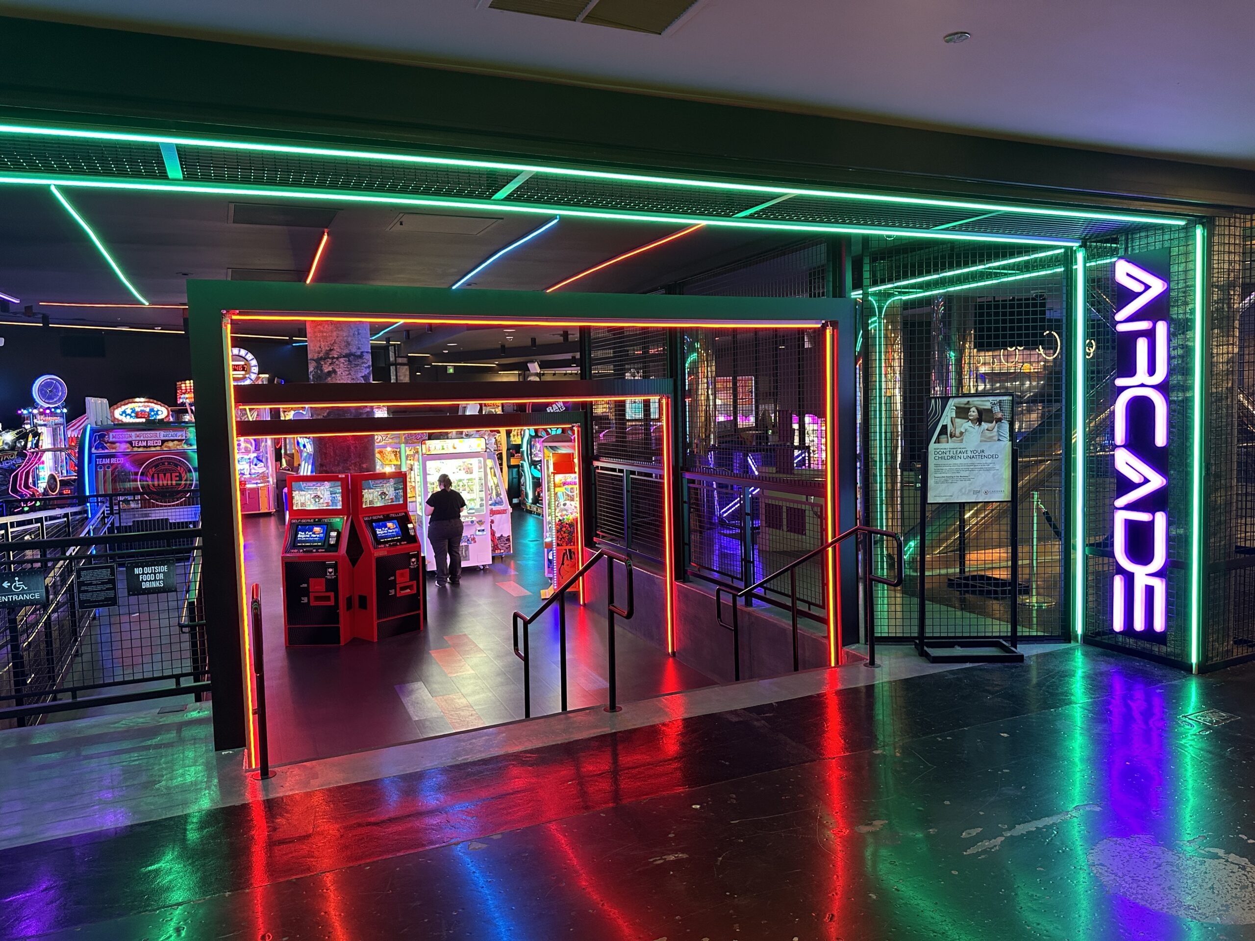 Entrance to the ARCADE, which is surrounded in green, purple, and red neon lights.