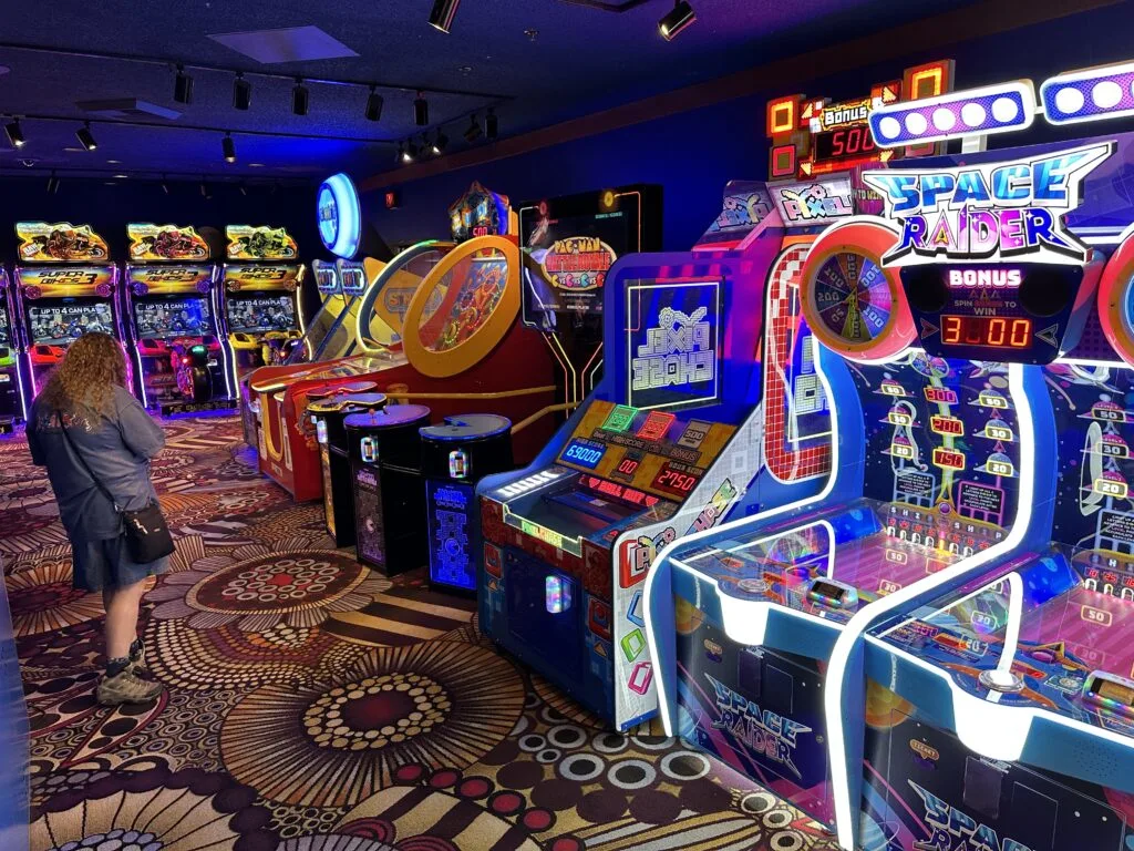 Various arcade games lined up against a wall. 