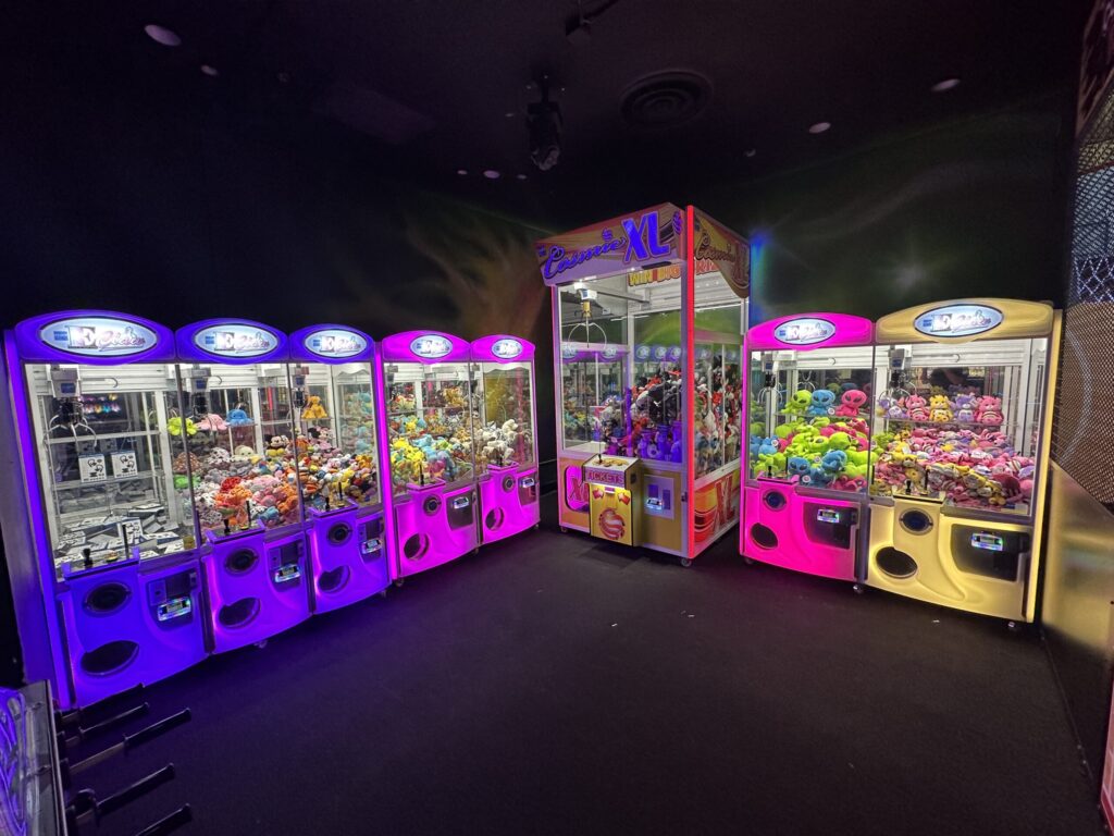 2 walls full of brightly lit claw games.