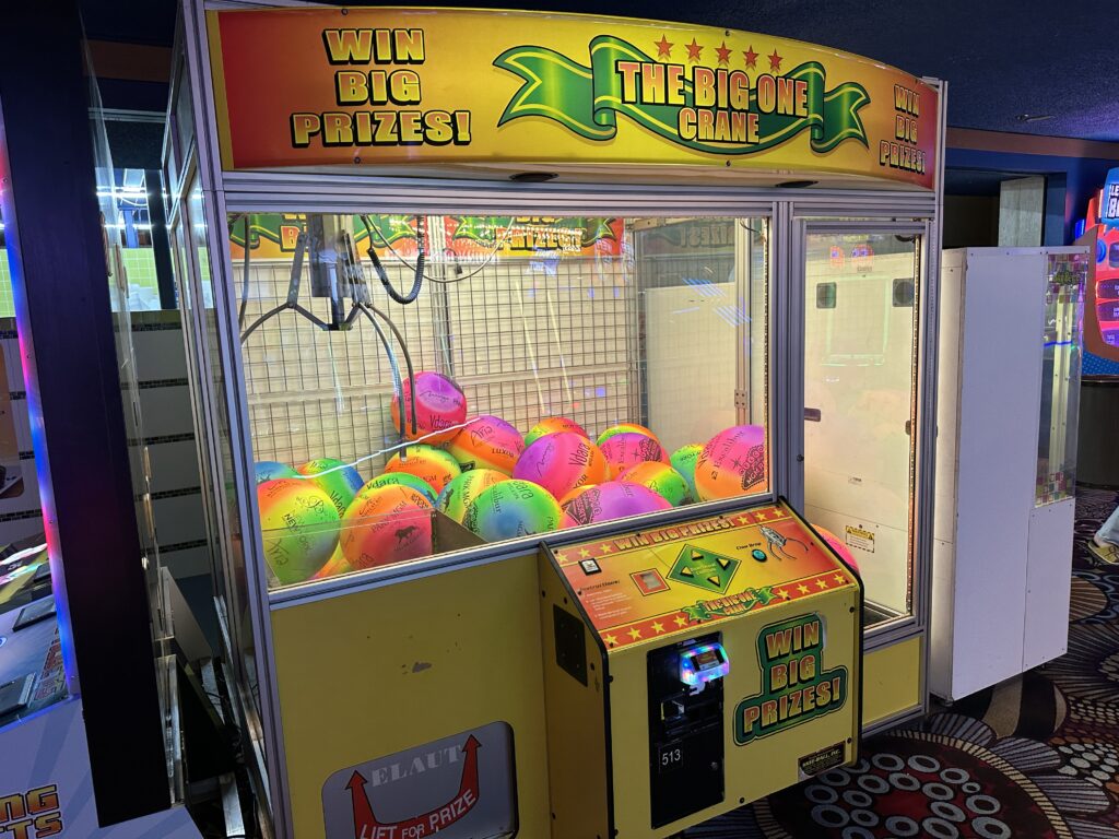 A "large prize" claw game that awards big colorful balls. 