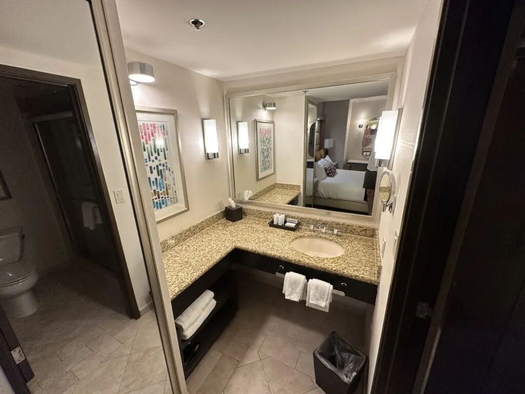 A single sink vanity with an L-shaped counter top. 