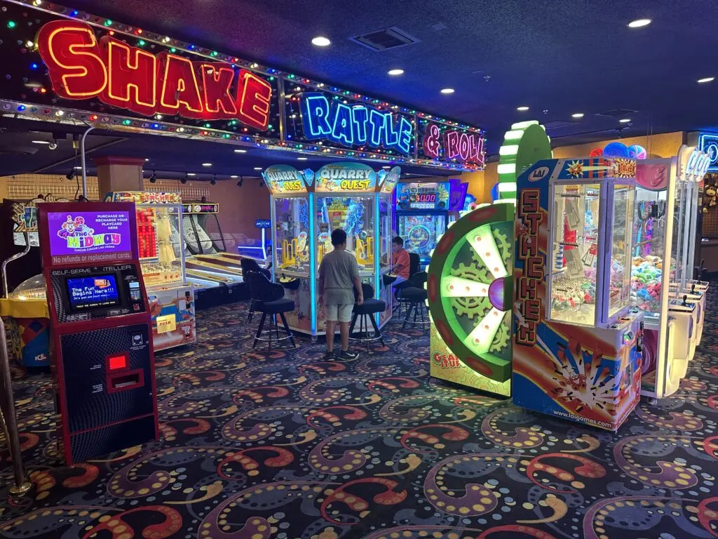 Arcade games with a neon sign above that says "Shake Rattle & Roll"