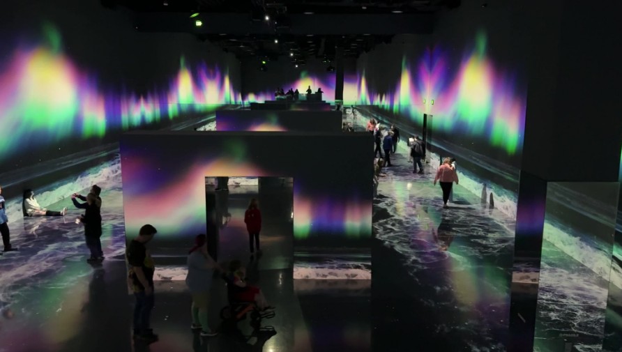 The northern lights and calming waves are projected on the screens.
