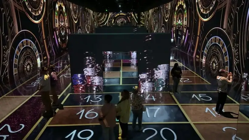 Roulette wheels and betting spaces projected on all surfaces in the room.