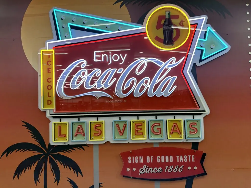 A Coca Cola neon sign modeled to look like the Welcome to Las Vegas sign.